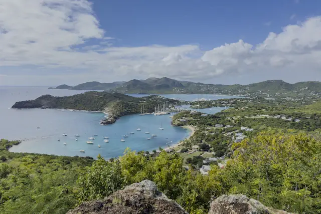 Sailboats in a sheltered bay below the green hills of Antigua