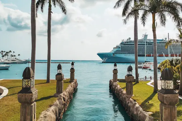 Palm trees beside a cruise ship in the harbour of Oranjestad, Aruba