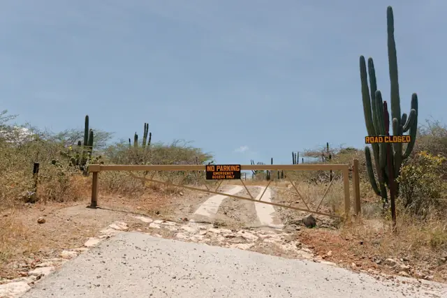 Cacti and a gated dirt road in Arikok National Park, Aruba