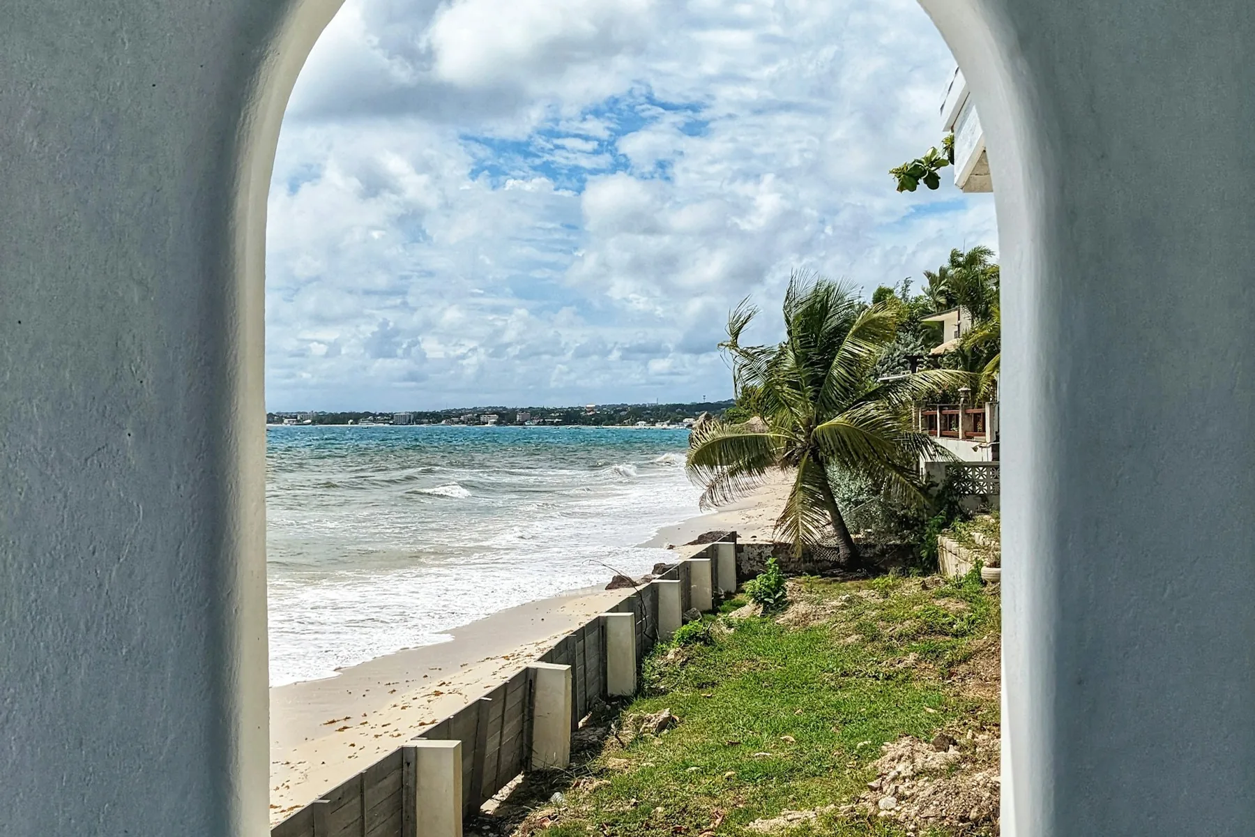 A view towards the sea through an opening on Enterprise Beach Road in Oistins