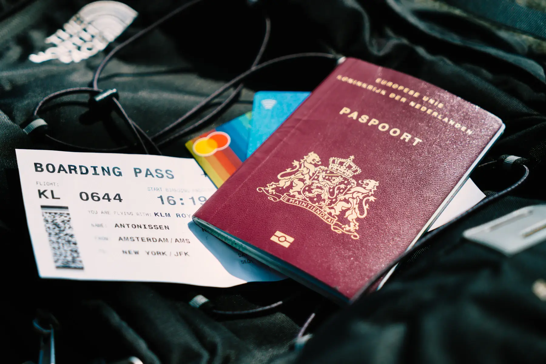 A passport and travel documents resting on a bag
