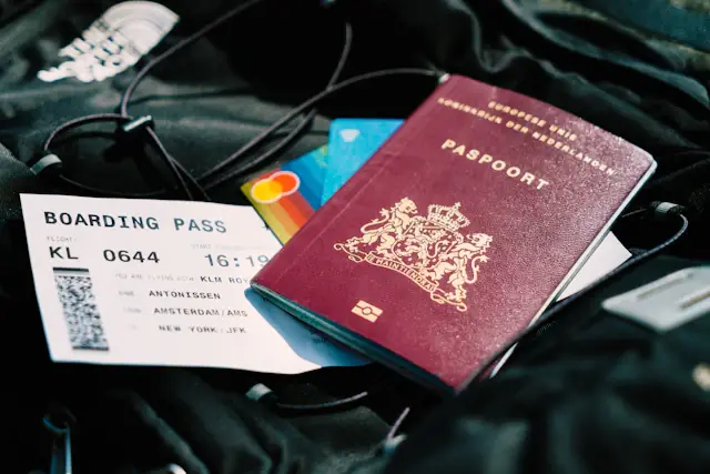 A passport and travel documents resting on a bag