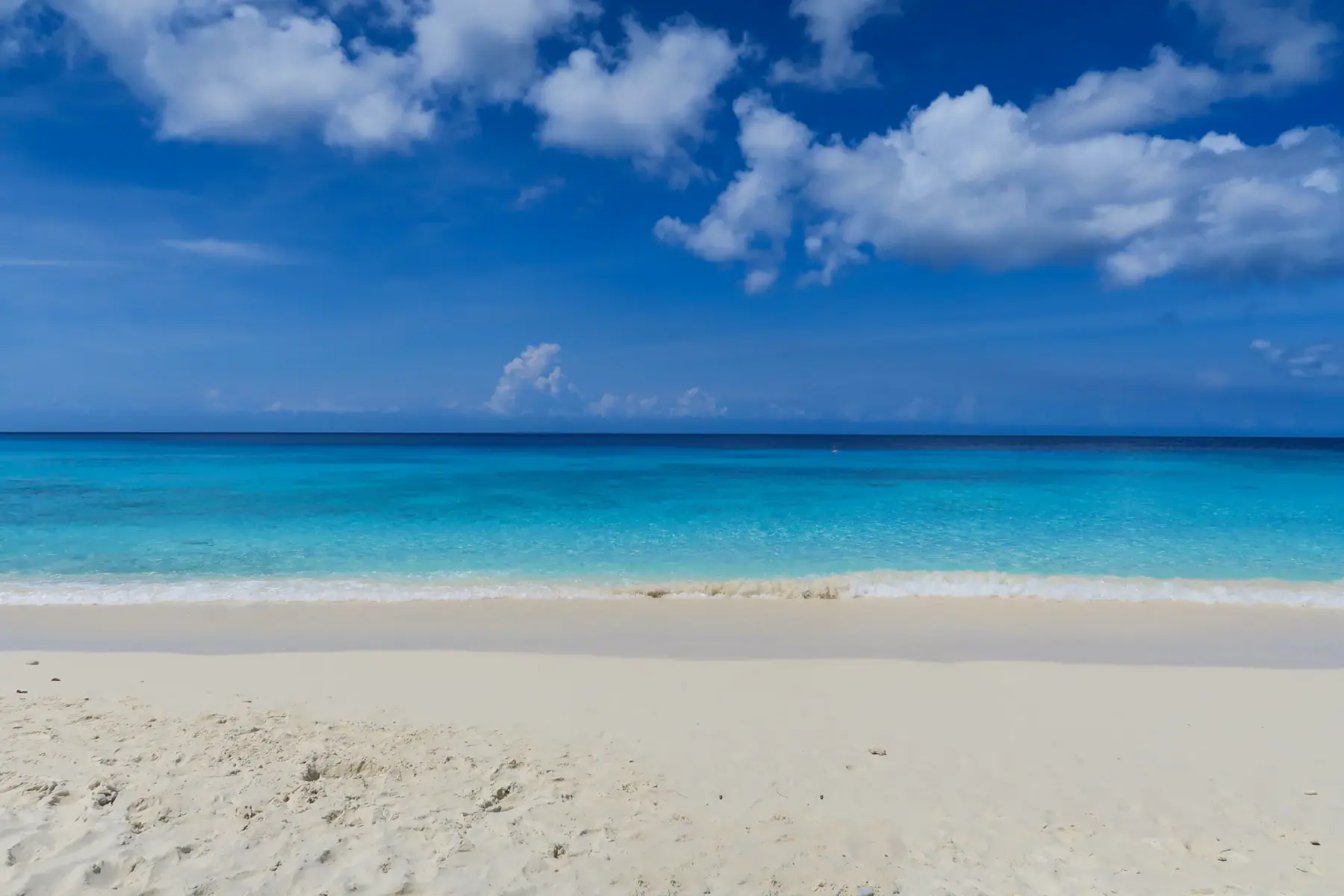 Clouds over turquoise water and white sand at Cas Abao, Curaçao