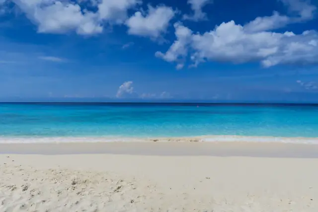 Clouds over turquoise water and white sand at Cas Abao, Curaçao