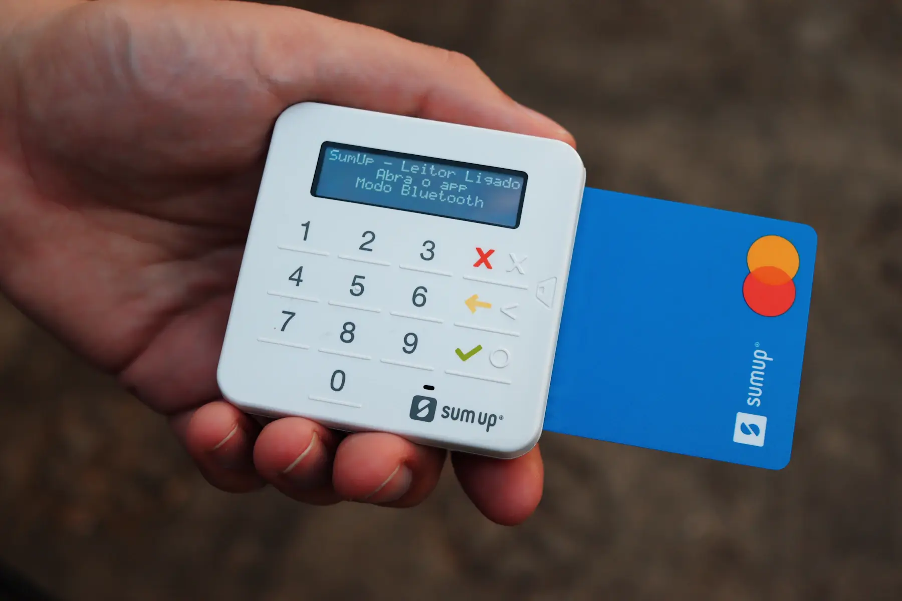 Handen met een bankpas bij een betaalterminal