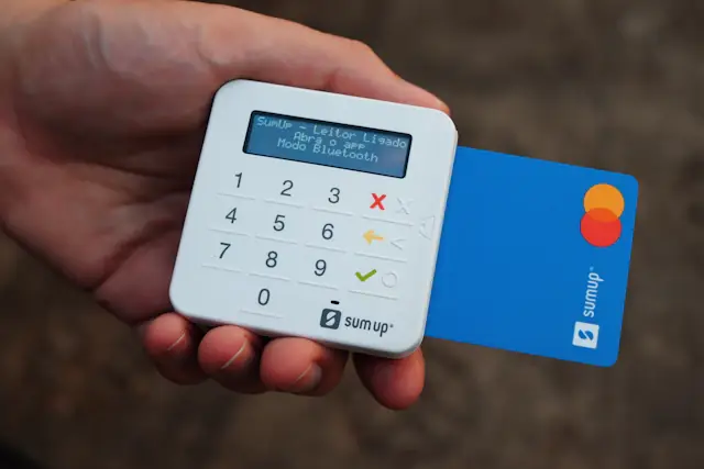 Hands holding a bank card near a payment terminal
