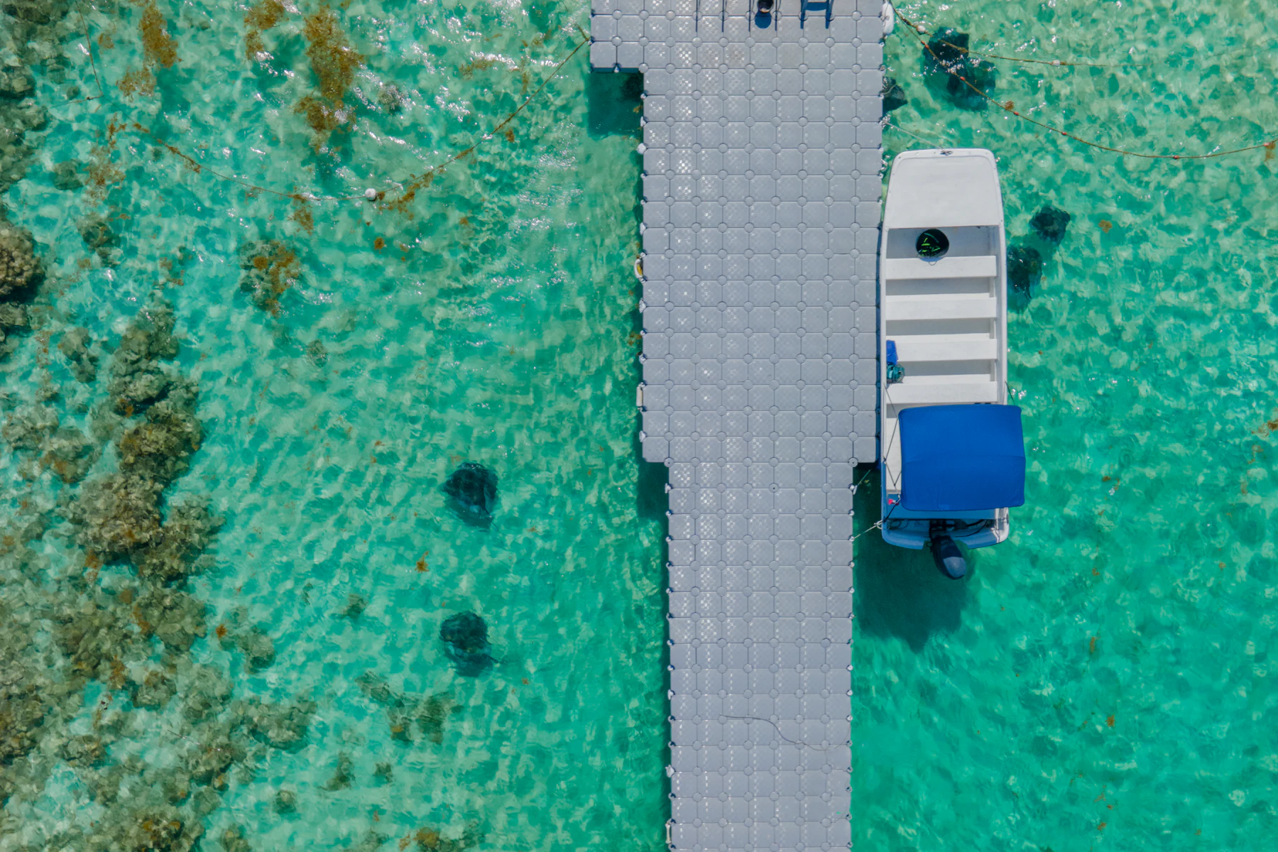 A boat beside a pier in the turquoise waters of Antigua and Barbuda