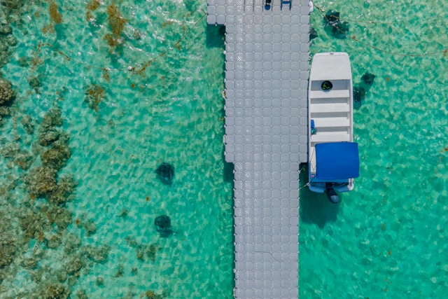 A boat beside a pier in the turquoise waters of Antigua and Barbuda