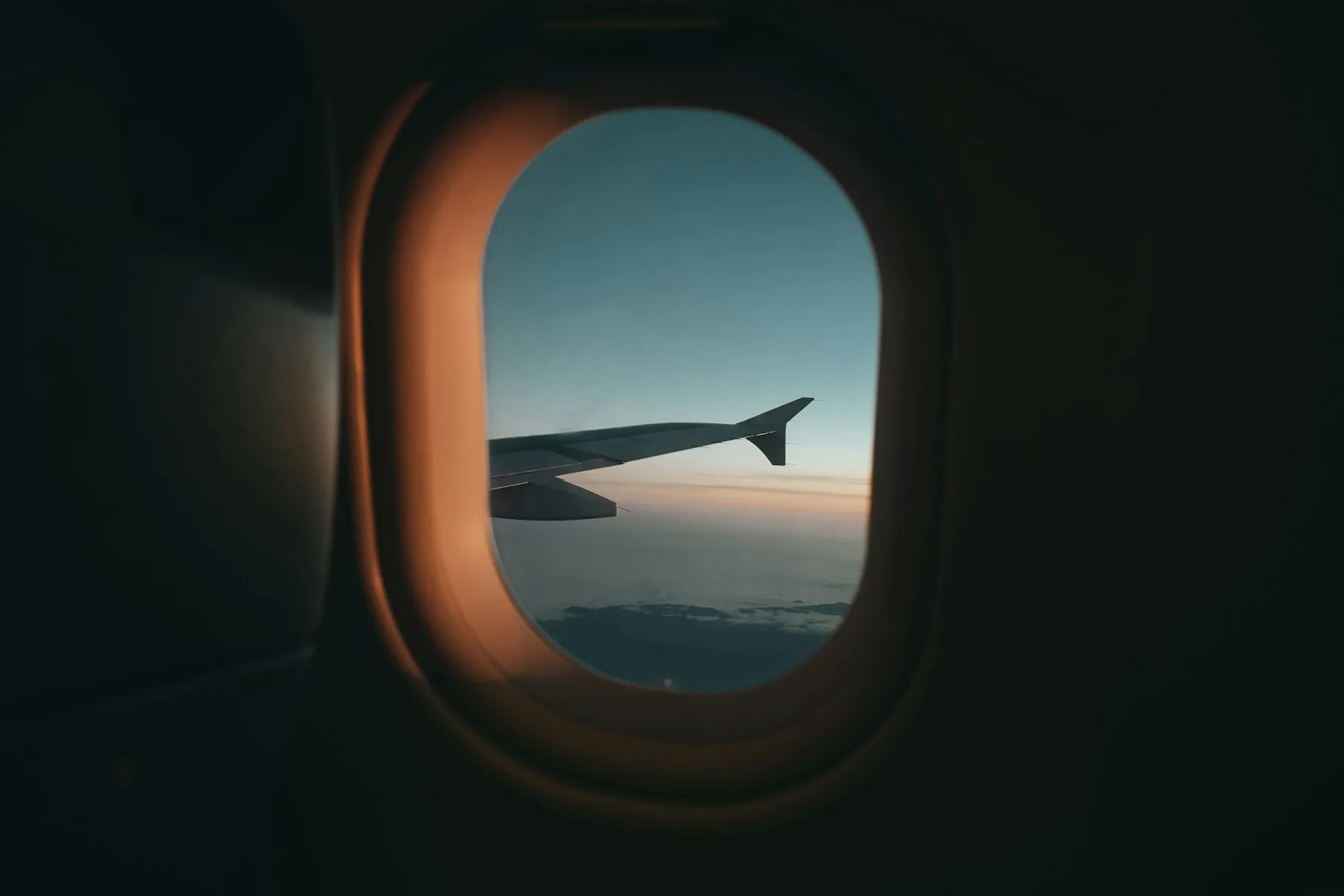 An aircraft wing seen through a cabin window