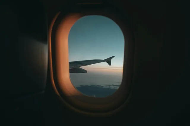 An aircraft wing seen through a cabin window