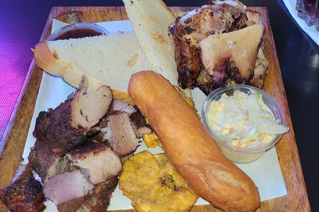 Jerk pork and chicken with side dishes, served in Kingston, Jamaica.
