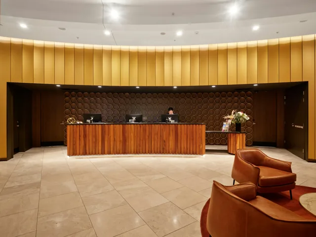 A wooden hotel reception desk with seating
